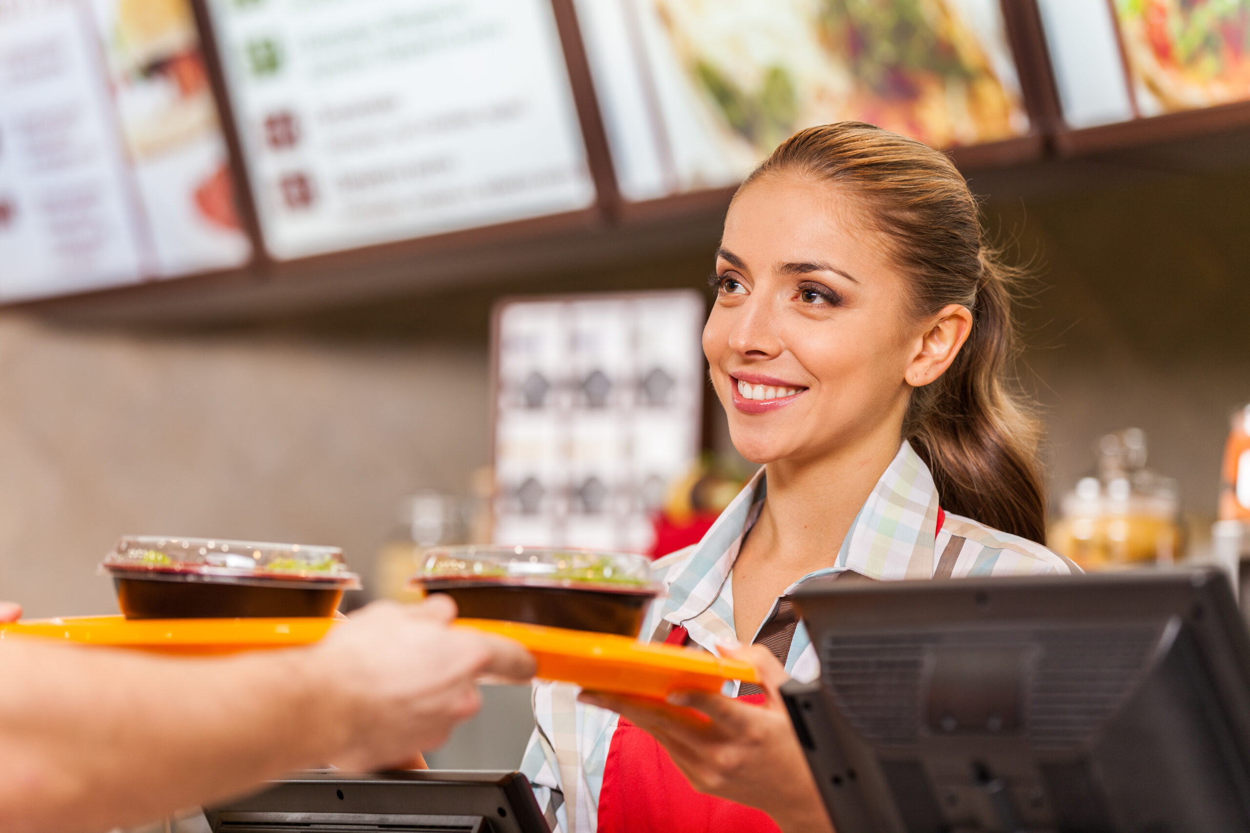 Employee serving two fast food meals