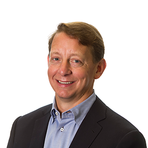 Tim Gruidl, Fishbowl Solutions president, poses for a headshot photo in a black suit against a white backdrop.